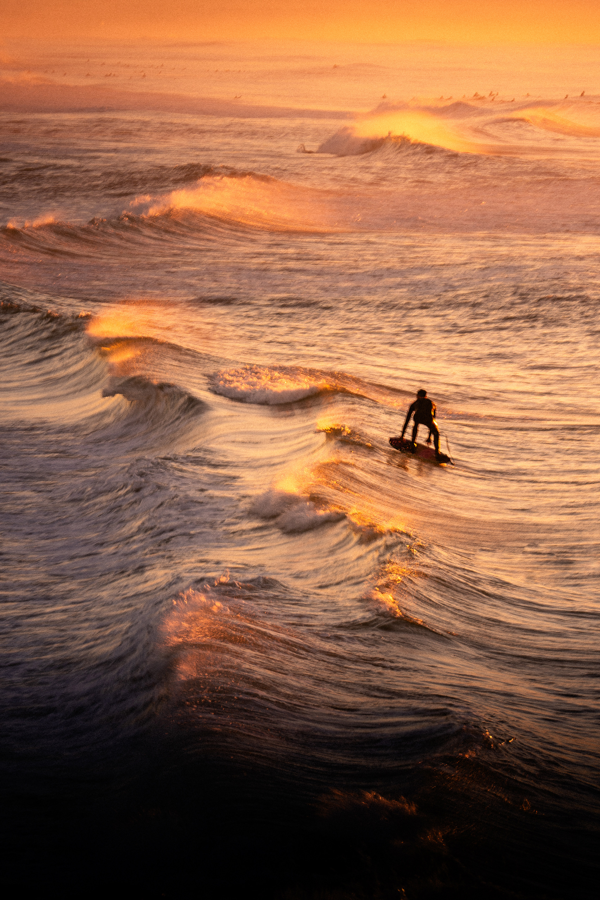 Coucher de soleil sur l'océan avec surfeur par Marie Dehayes